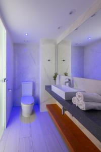 La salle de bains blanche est pourvue d'un lavabo et de toilettes. dans l'établissement Kokkinos Boutique Hotel, à Protaras