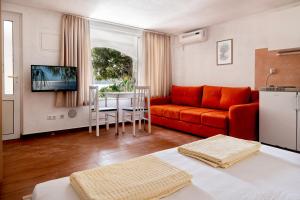 a living room with an orange couch and a table at Apartments Sentic in Neum