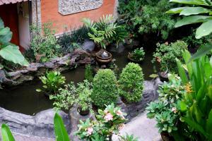 un jardín con muchas plantas y un estanque en Seminyak Paradiso Hotel en Seminyak