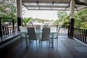 a dining room with a table and chairs on a balcony at Blue Moon Design House in Ko Samed