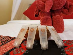 a group of three toothbrushes on a bed with a teddy bear at Ombak Dive Resort Perhentian Island in Perhentian Islands