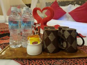 a tray with cups and water bottles on a bed at Ombak Dive Resort Perhentian Island in Perhentian Islands