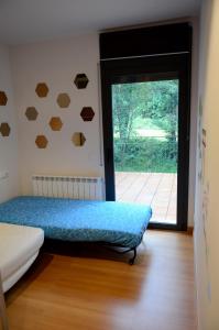 a room with a bed and a door with a window at Casa Alba in Ribes de Freser