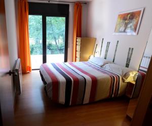a bedroom with a bed with a colorful striped blanket at Casa Alba in Ribes de Freser