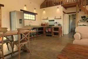 a large kitchen with a table and a refrigerator at Dalmore Guest Farm in Bergville