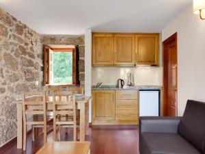 a kitchen and dining room with a table and a kitchen and a counter at Quinta do Bárrio - Manor Guest House in Terras de Bouro