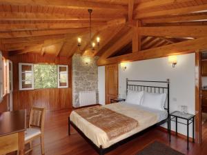 a bedroom with a large bed in a room with wooden ceilings at Quinta do Bárrio - Manor Guest House in Terras de Bouro +63 photos