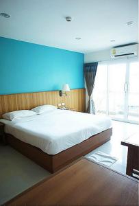 a bedroom with a large bed with a blue wall at D Apartment in Pattaya +14 photos