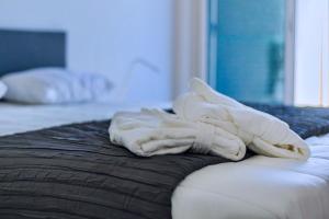 uma pilha de toalhas brancas sentadas em cima de uma cama em vilamaria apartment em Porches