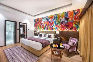 a bedroom with a bed and a painting on the wall at Royal Orchid Resort & Convention Centre, Yelahanka Bangalore in Bengaluru +61 photos