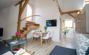 a small living room with a table and a staircase at Apartamentai Niden - su terasa ir vaizdu i marias Nidos centre in Nida