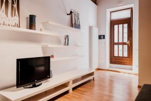 a living room with a tv on a white wall at Casa Romeo in Cuneo