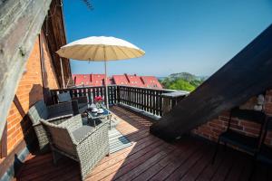 einen Balkon mit einem Tisch und einem Sonnenschirm in der Unterkunft Apartamentai Niden - su terasa ir vaizdu i marias Nidos centre in Nida