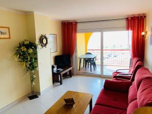 sala de estar con sofá rojo y mesa en AwayDays - BIII 8-3 - Appartement 8ème étage vue Mer, en Empuriabrava