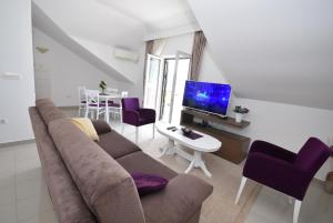 a living room with a couch and a tv at Grifone Coastline in Herceg-Novi