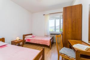 a bedroom with two beds and a window at Apartment Kneže in Račišće