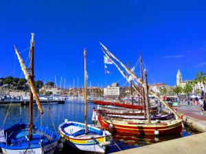 three boats are docked at a dock in a harbor at Hyper Centre Sanary 3 chambres parking balcon clim wifi in Sanary-sur-Mer