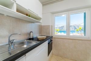 a kitchen with a sink and a window at Apartment Kneže in Račišće +20 photos