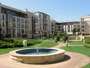 une fontaine au milieu d'un parc avec des bâtiments dans l'établissement Garden Corner, à Cracovie