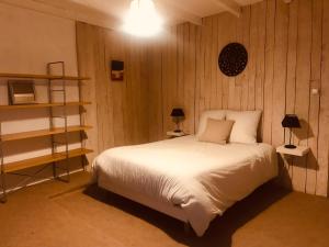 サン・レミ・ド・プロヴァンスにあるM&S - Apartment in Saint Rémy de Provenceの白いベッドと木製の壁が備わるベッドルーム1室が備わります。