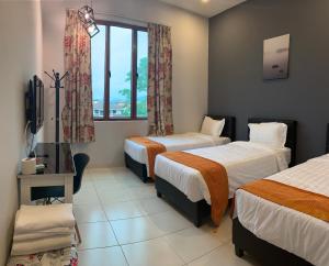 怡保的住宿－白宮民宿，酒店客房设有两张床和窗户。