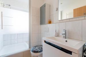 een badkamer met een wastafel, een toilet en een spiegel bij Private Apartment in Ronnenberg