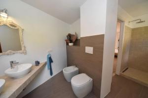 a bathroom with a toilet and a sink and a mirror at Villa EnriMar in Capoliveri +36 photos