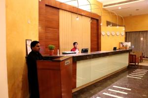 dos personas sentadas en una recepción en un vestíbulo en VITS Aurangabad, en Aurangabad