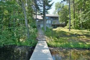 Una pasarela que conduce a una casa en el bosque en Serenity On Lake Owen Condo, en Cable