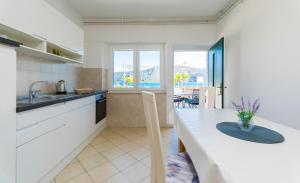 a kitchen with a counter top and a table at Apartment Kneže in Račišće