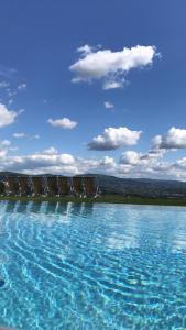 a large pool of blue water with chairs in it at Agriturismo Fattoria Di Maiano in Fiesole