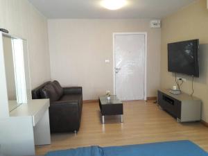 a living room with a couch and a flat screen tv at Plum Phahol89, Prachathipat in Ban Talat Rangsit +5 photos