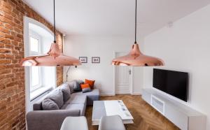 Una sala de estar con un sofá y un televisor. en Apartament SWEET TIME, en Wroclaw