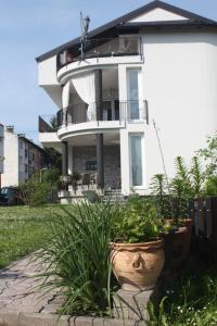 a white building with plants in front of it at LGP Exclusive Apartment in Bihać