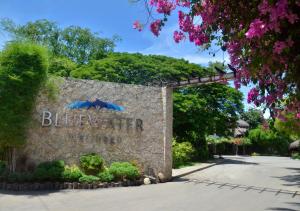a sign for bluerater with trees and flowers at Bluewater Maribago Beach Resort in Mactan