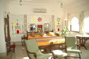 a bedroom with a large bed and chairs in it at Raj Niwas in Udaipur