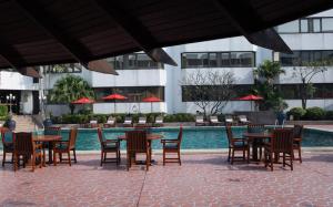 a group of tables and chairs next to a pool at Amari Don Muang Airport Bangkok in Bangkok