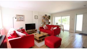 a living room with red couches and a table at ★ Luxury Oxford Apartment ★ Sleeps 4, Free Parking in Oxford