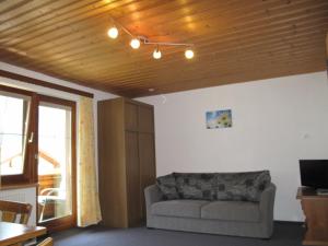 a living room with a couch and a wooden ceiling at sHoamatl in Pfunds