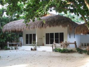 a small house with a thatched roof at Bluewater Maribago Beach Resort in Mactan
