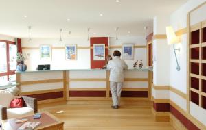 a pharmacist standing at a counter in a pharmacyacistacist at Residence Le Montana - maeva Home in La Mongie