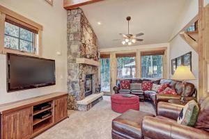 a living room with a television and a stone fireplace at 6508 Settlers Creek Townhomes in Keystone