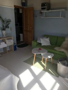 a living room with a green couch and a table at Skovgården in Hillerød