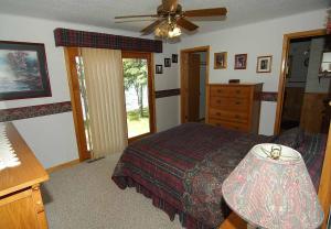 Un dormitorio con una cama y un ventilador de techo. en Ranch-Style Seidls Home, en Namekagon