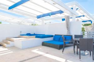 a patio with blue furniture and a table and chairs at Penthouse De Soleil South Beach - on Ocean Drive Miami Beach in Miami Beach