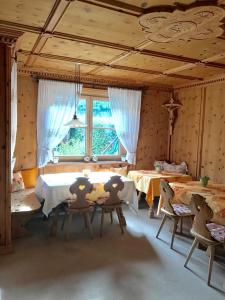 a room with two tables and chairs and a room with windows at Garni Hotel Burgleitenhof in Lana