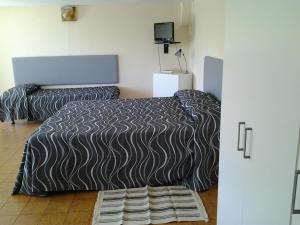 a bedroom with two beds and a tv on the wall at Residence La Carruba in Diano Marina +77 photos