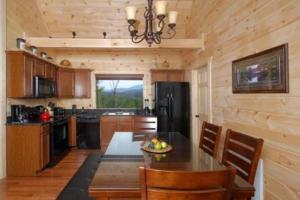 eine Küche mit einem Tisch und einem schwarzen Kühlschrank in der Unterkunft A Suite Mountain Retreat Cabin in Pigeon Forge