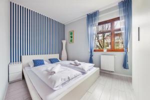 グダニスクにあるApartamenty Sun & Snow Jelitkowskaのベッドルーム(青いカーテン付きの白いベッド1台付)