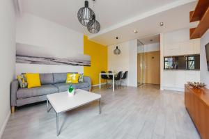 a living room with a couch and a table at Apartamenty Sun & Snow Jelitkowska in Gdańsk